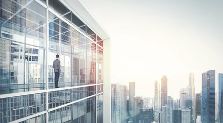 Businessman standing on a balcony and looking at city