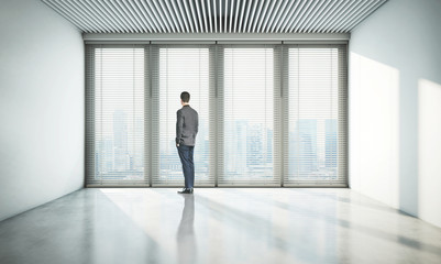 businessman looking at city through window