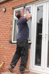 A Window fitter removing old windows in preparation for new ones