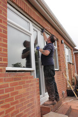 A Window fitter removing old windows in preparation for new ones