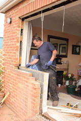 A Window fitter removing old windows in preparation for new ones