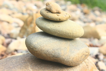 Fototapeta na wymiar Stones pyramid near small river symbolizing zen