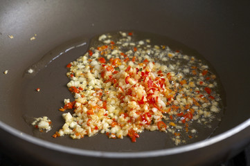 fry chili and garlic in black pan