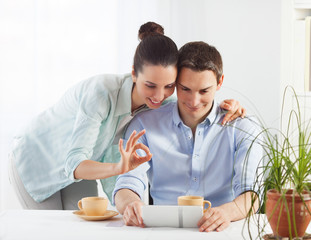 Portrait of happy couple shopping online using digital tablet