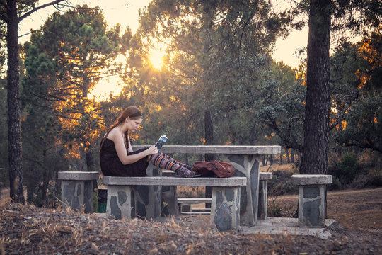 Young woman reading a book in the forest