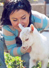 Girl with baby goat. focus at goat