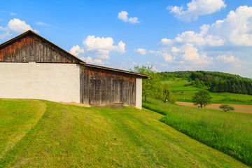 Obraz premium Wooden barn on farming field and blue sky, Austria
