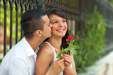 Young man giving red rose to his girlfriend