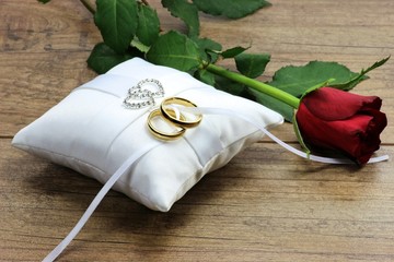 goldene Trauringe auf weißem Ringkissen	
