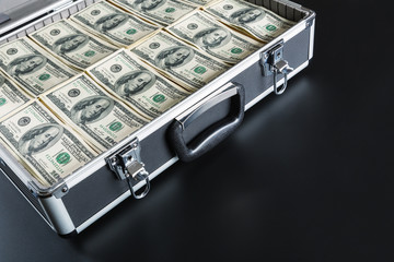 Case full of money on gray background