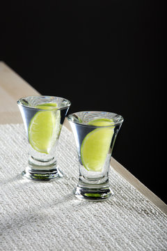 Two glasses of vodka with lime on the table