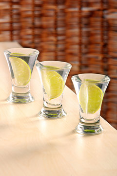 Three glasses of vodka with lime on the table