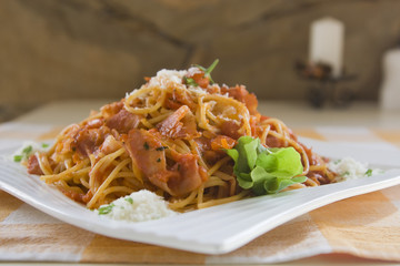 Spaghetti with bacon on the table.