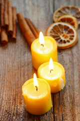 Fototapeta na wymiar Beautiful candles and juicy oranges on jute table cloth