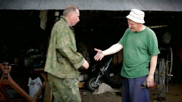 Two village mens is meeting in the morning in garage