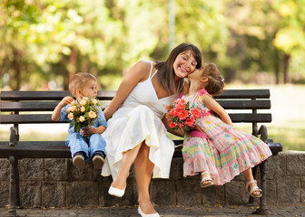 Two little children expressing love and affection to mommy.