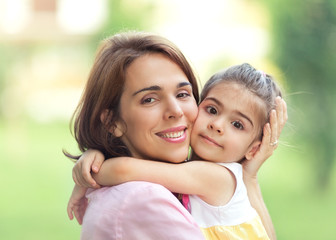 Mother and cute little daughter portrait outdoors.