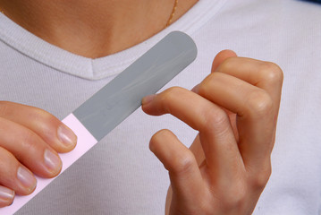 Mujer limando uñas con una lima.Lijando uñas.