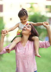 Mother and little daughter having fun outdoors.