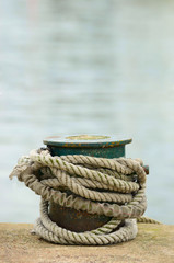 Fototapeta na wymiar ship rope knotted around a bollard