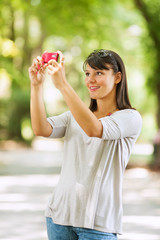 Obraz premium Beautiful young woman taking photo sith her smartphone.