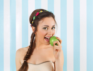 Beautiful young woman eating a fresh green apple.Studio shot.