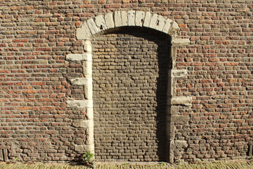 Hintergrund historische  Backsteinwand mit zugemauerter Tür