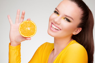 Young brunette with orange in her hand