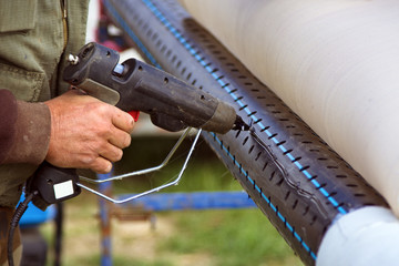 Worker fixing filter paper on pipe with hot plastic glue