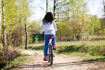 beautiful young woman with mountain bicycle in spring forest