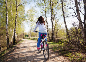 Fototapeta na wymiar beautiful young woman with mountain bicycle in spring forest