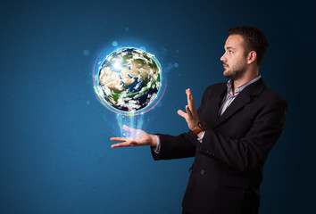 Businessman holding glowing earth globe