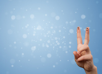 Happy finger smileys with empty blue bokeh background