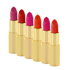 beautiful lipsticks in golden tube isolated on white