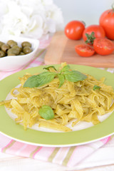 Delicious pasta with pesto on plate on table close-up