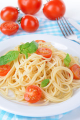 Delicious spaghetti with tomatoes on plate on table close-up