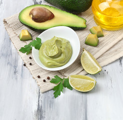 Fresh guacamole in bowl on wooden table