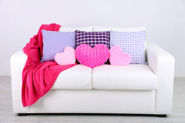 Pink heart shaped pillows, plaid on white sofa