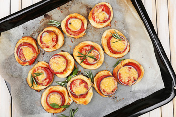 Small pizzas on baking paper close up