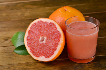 Ripe grapefruit with juice on table close-up