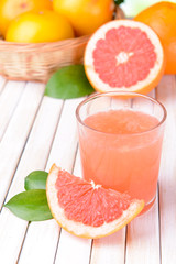 Ripe grapefruit with juice on table close-up