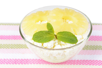 Bowl of tasty cottage cheese with pineapple, isolated on white