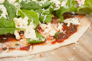 Spinatpizza auf Holzbrett