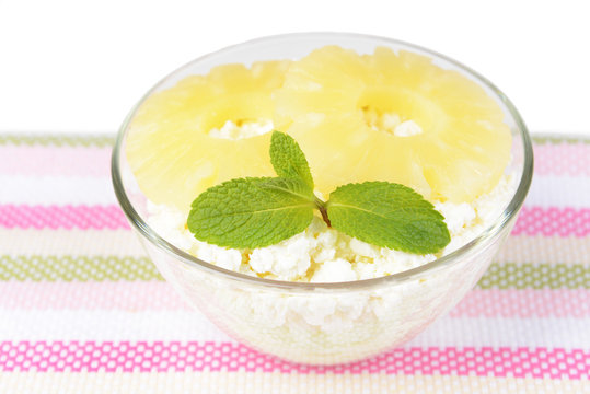 Bowl of tasty cottage cheese with pineapple, isolated on white