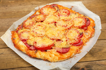 Homemade pizza on baking paper close up