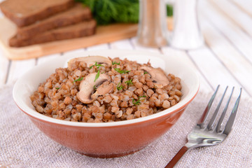 Boiled buckwheat in bowl on table close-up