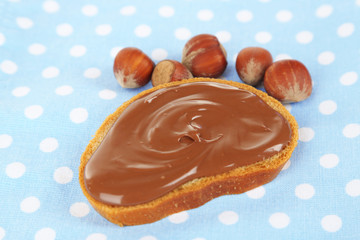 Bread with sweet chocolate hazelnut spread on tablecloth