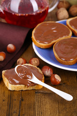 Bread with sweet chocolate hazelnut spread on plate on table