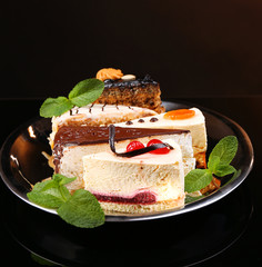 Assortment of pieces of cake, on dark background © Africa Studio
