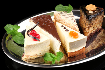 Assortment of pieces of cake, on dark background © Africa Studio